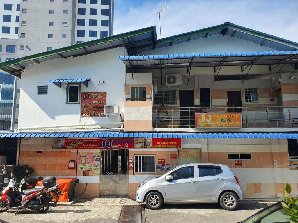 a white car parked in front of a building at OYO 90972 Jj Homestay in Miri