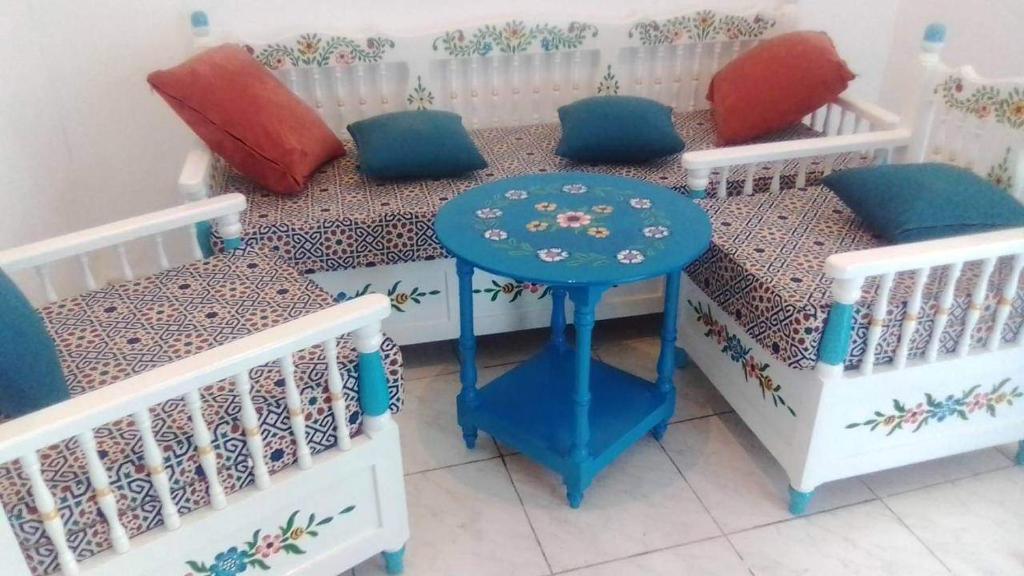 a room with two beds with a table and chairs at Maison de ville sousse in Sousse