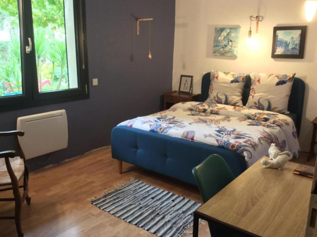 皮耶爾拉特的住宿－Chambres Doubles La Cigale，一间卧室配有一张蓝色的床和一张桌子