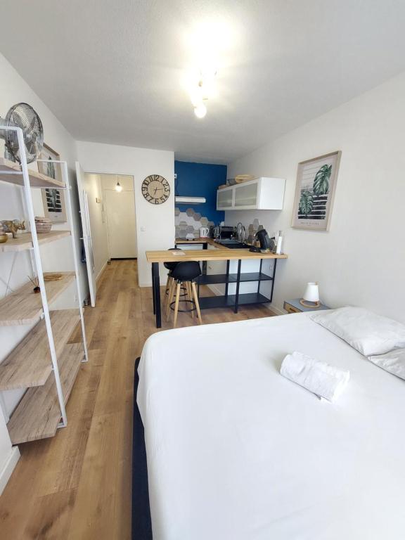 1 dormitorio con cama, escritorio y cocina en Studio de charme - Idéal Couple & Pro - Calme, en Lons