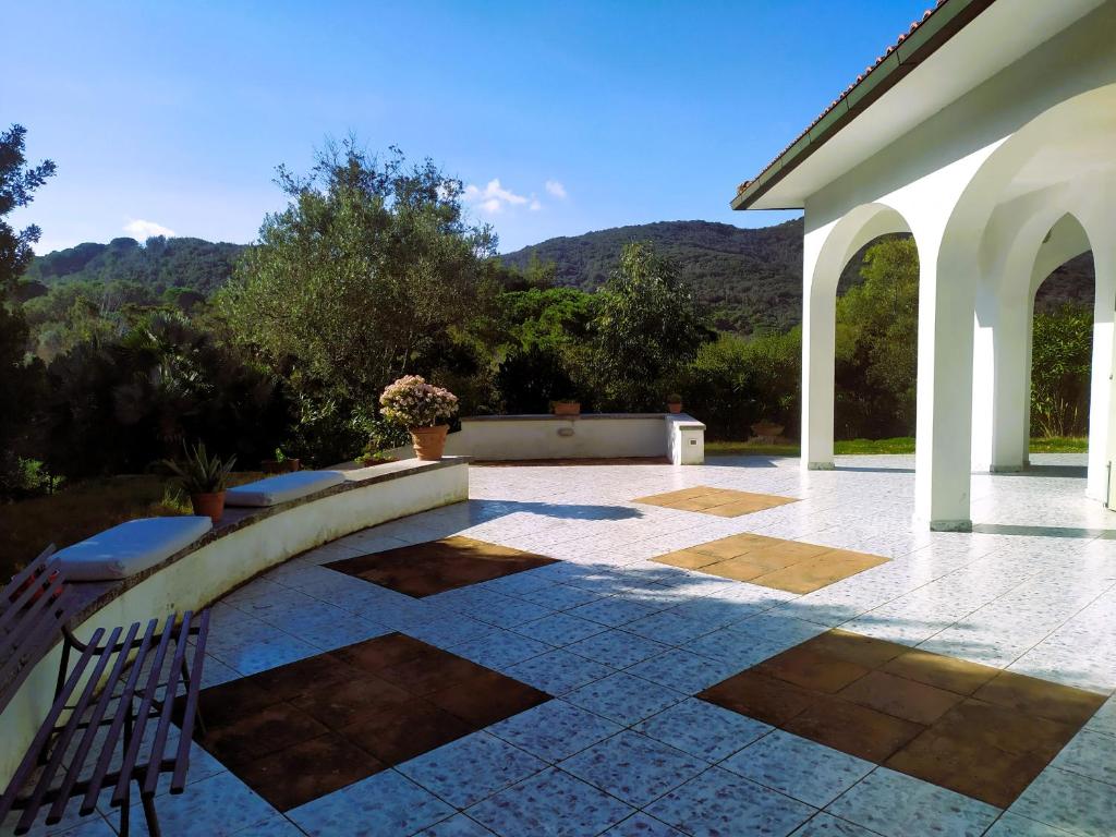 a patio with two chairs and a building at B&B Casa Corbezzolo in Procchio