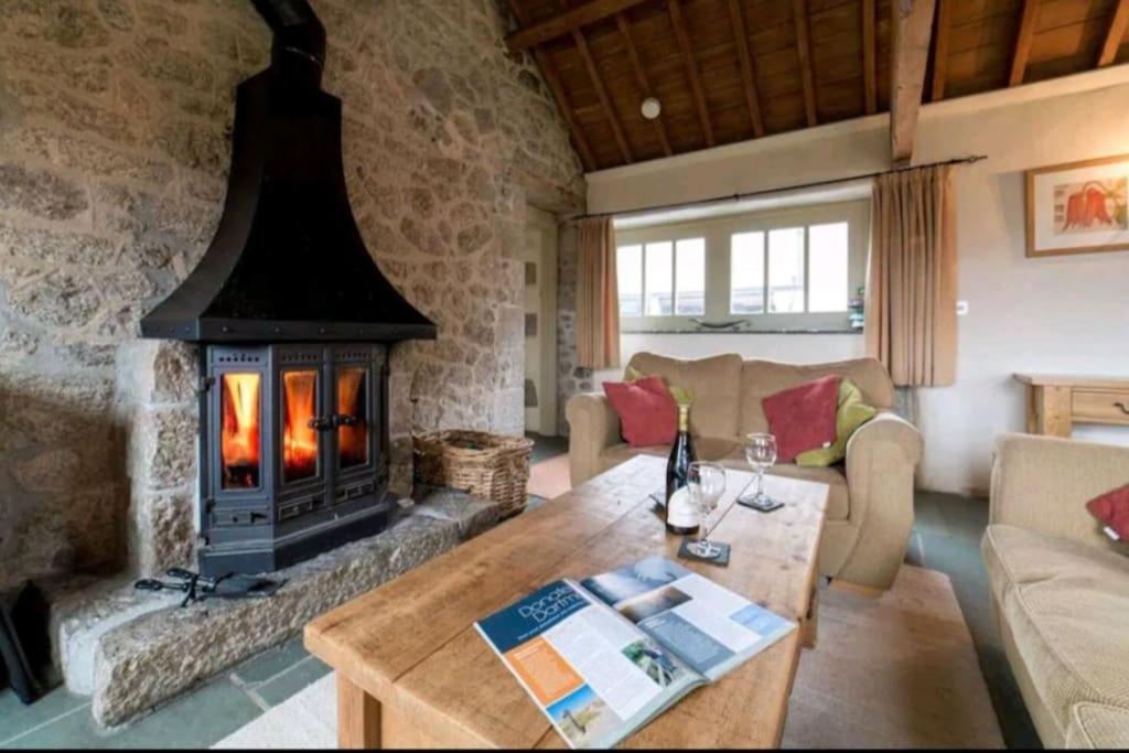 sala de estar con chimenea y mesa en Haytor Rocks, Dartmoor escape en Bovey Tracey