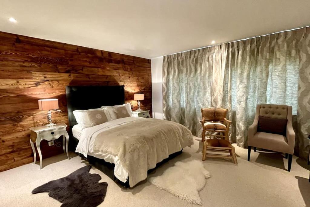 ein Schlafzimmer mit einem Bett und einer Holzwand in der Unterkunft Spacious Family Apt Flims close to Lake Cauma in Flims