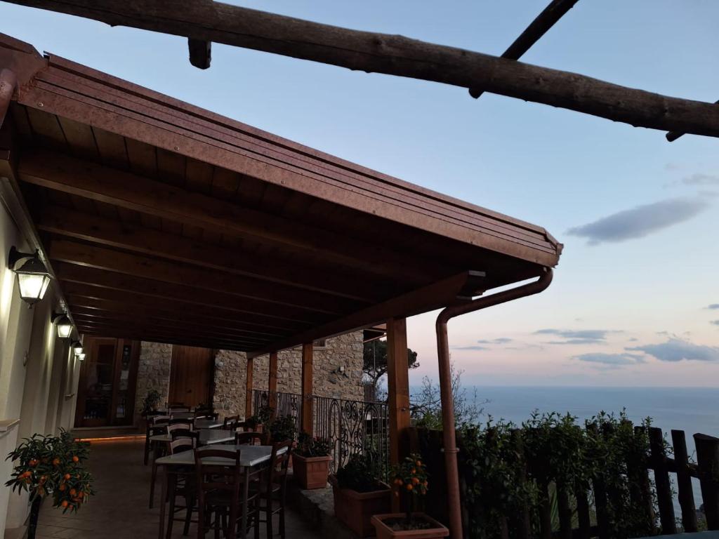 a restaurant with tables and chairs on a balcony at Agriturismo Orrido di Pino in Agerola