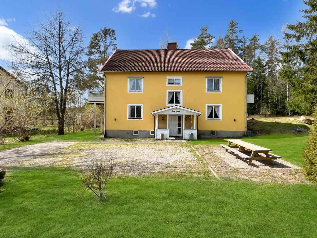 a yellow house with a picnic bench in front of it at Accommodation For Construction Workers, Växjö Area 