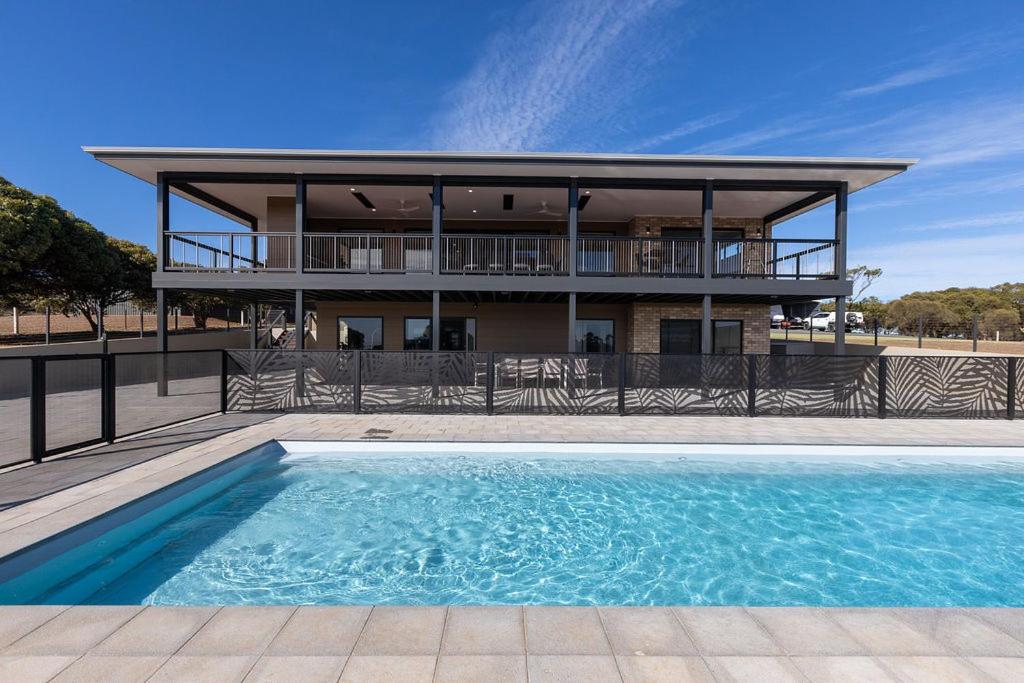 a house with a swimming pool in front of a building at The Lux Country Retreat - heated swimming pool - immaculate views and stylish comfort! in Port Lincoln
