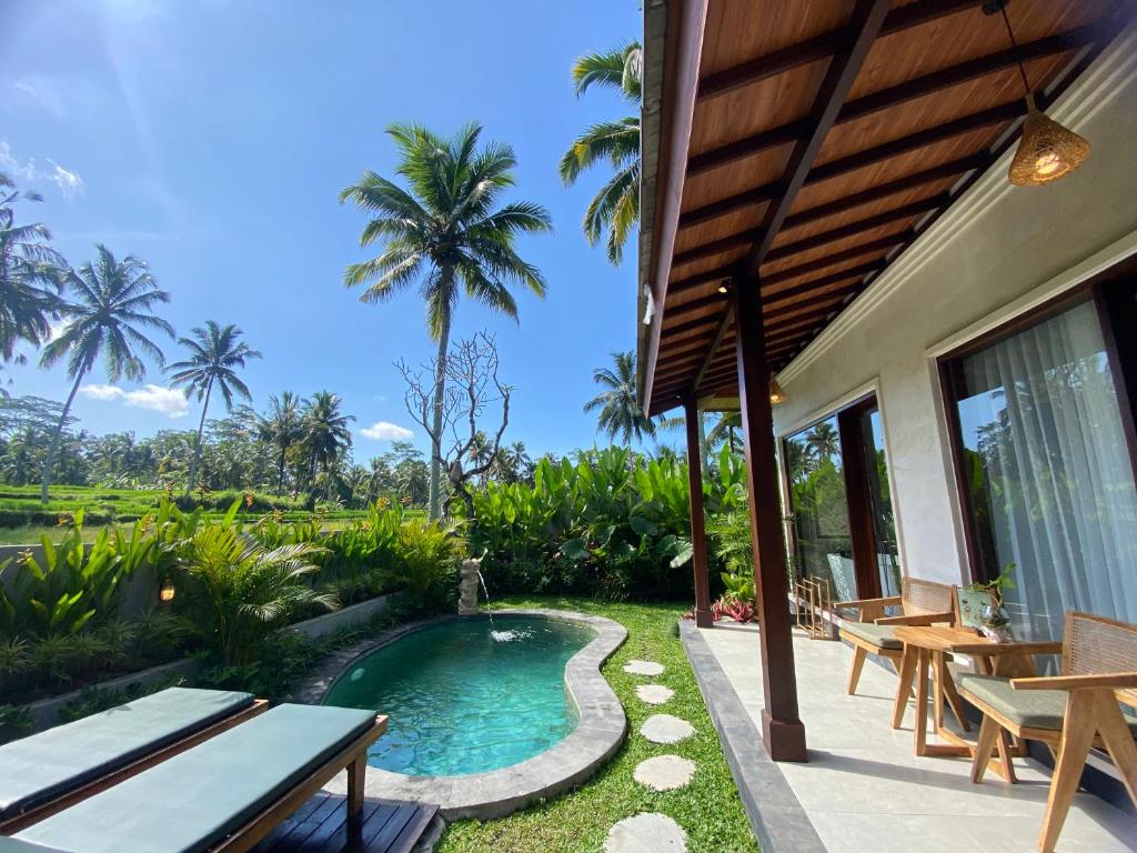 a villa with a swimming pool and a patio at Arvanya Villa Ubud in Tegalalang