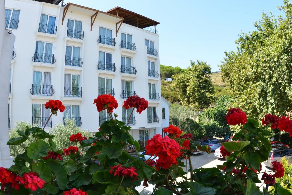 un edificio con flores rojas delante de él en Kırtay Hotel Erdek en Erdek