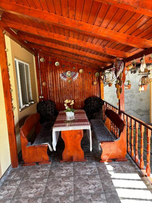 a patio with a table and chairs on a porch at Casa Otilia in Chişcău