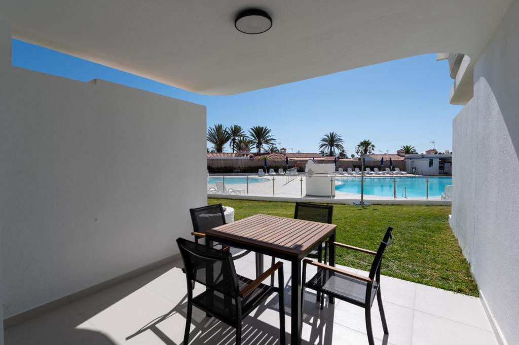 stół i krzesła na balkonie z widokiem na basen w obiekcie Pool Apartment Tamaran w mieście Playa del Ingles