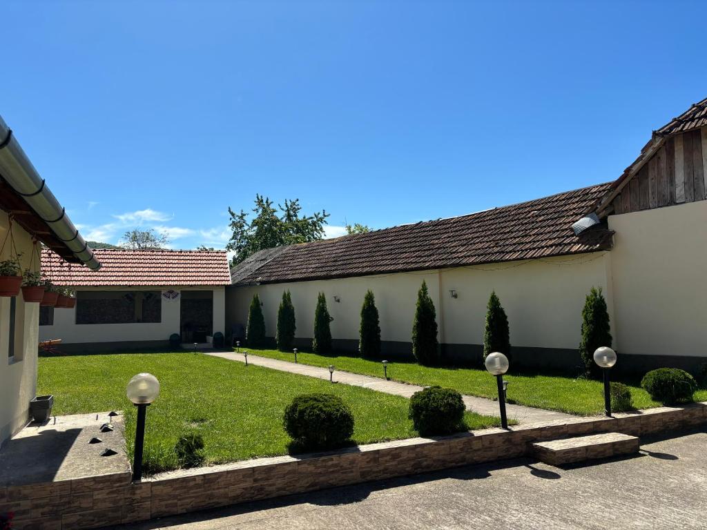 a courtyard of a building with a row of trees at Casa Otilia in Chişcău
