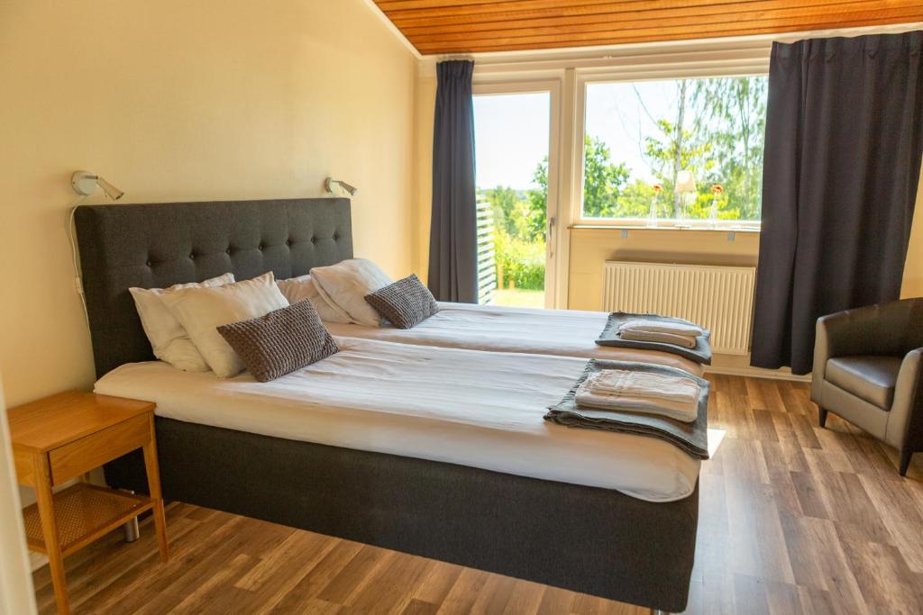 Cama grande en habitación con ventana en Breviken Golf & Hotell, en Brevik
