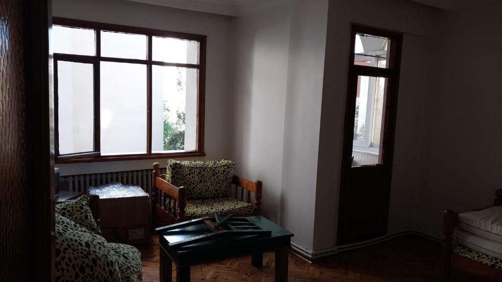 a living room with two chairs and a table and windows at Flat Kavisli in Istanbul