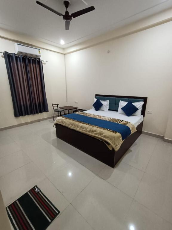 1 dormitorio con 1 cama con almohadas azules y blancas en Hotel JP Inn, en Lucknow