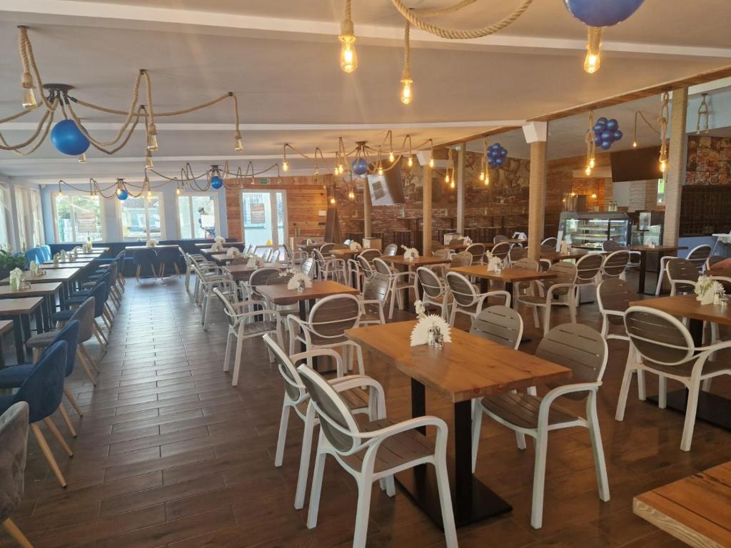 a dining room with wooden tables and chairs at OW Gromada Pod Bukami in Międzyzdroje