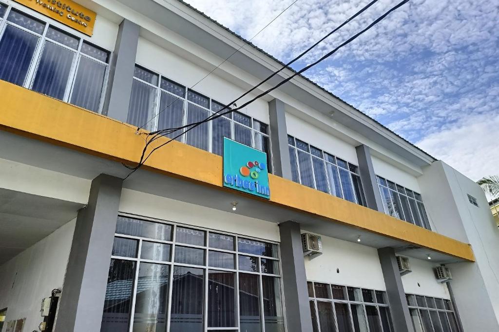 un edificio blanco con una señal azul en OYO 93929 Erbee Inn en Makassar