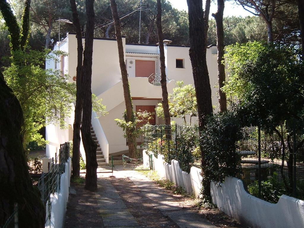 a house with a fence next to a sidewalk at Villa Bianca in Rosolina Mare