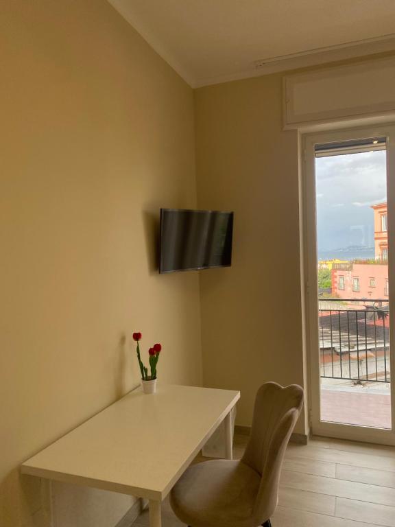 a dining room with a white table and a window at Casa Zelia in Ercolano