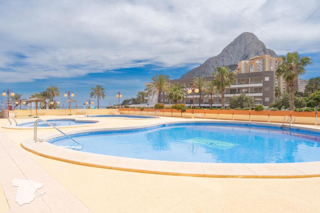 a swimming pool with a mountain in the background at Zafiro in Calpe
