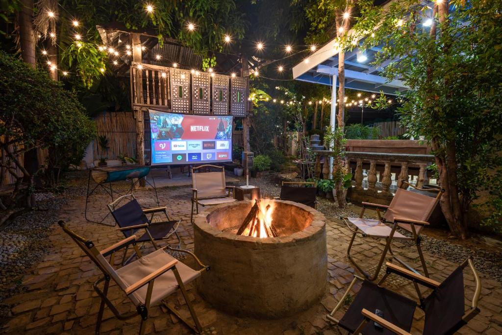 un focolare in un cortile con sedie e luci di Villa Raya w Outdoor Cinema, Bonfire, Treehouse & Parking a Vigan