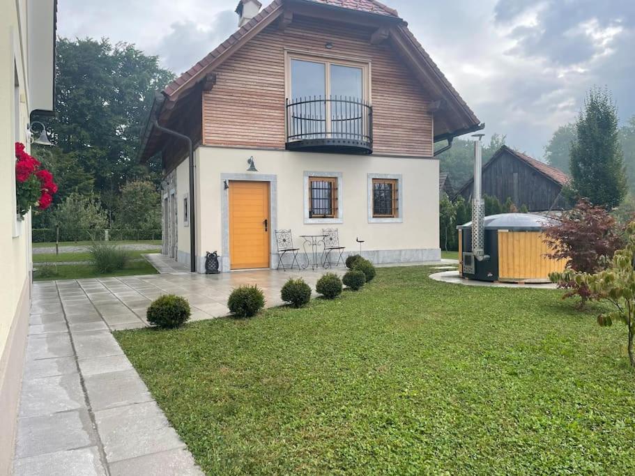 a house with a yellow door in a yard at Sweet Retreat in Trebelno