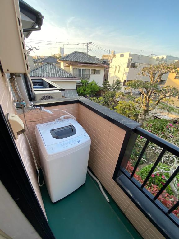 福岡市にあるGest Residence Hakata Tenjin self check inの洗濯機、景色を望むバルコニー