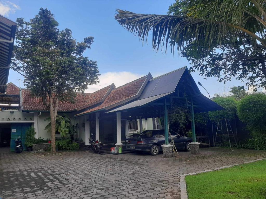 dom z samochodem zaparkowanym przed nim w obiekcie Capital O 93938 Wisma Pamungkas Syariah w mieście Sleman