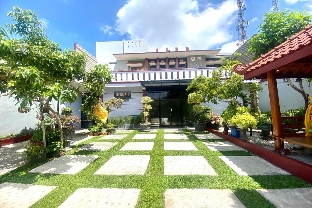 un patio de un edificio con césped y árboles en Capital O 93942 Griya Singgah Berkah Syariah en Purworejo