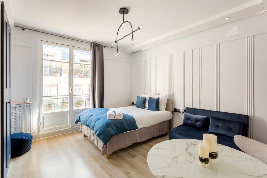une chambre avec un lit et une table dans l'établissement Square Villaret Studio, à Paris