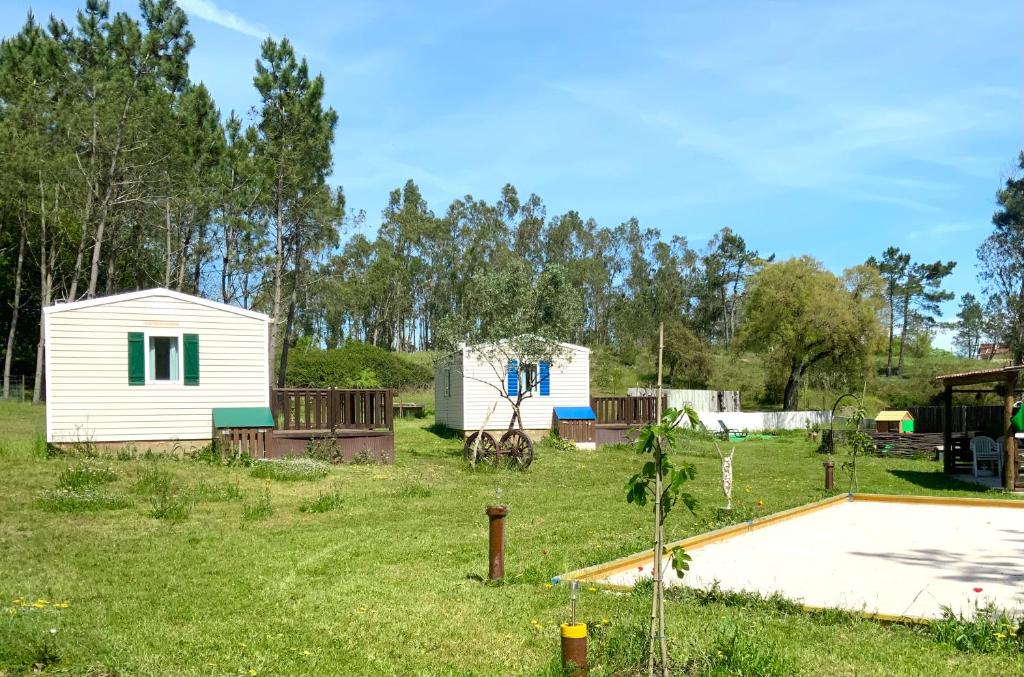 een achtertuin met een klein huisje en een schuur bij Clareira in Quiaios