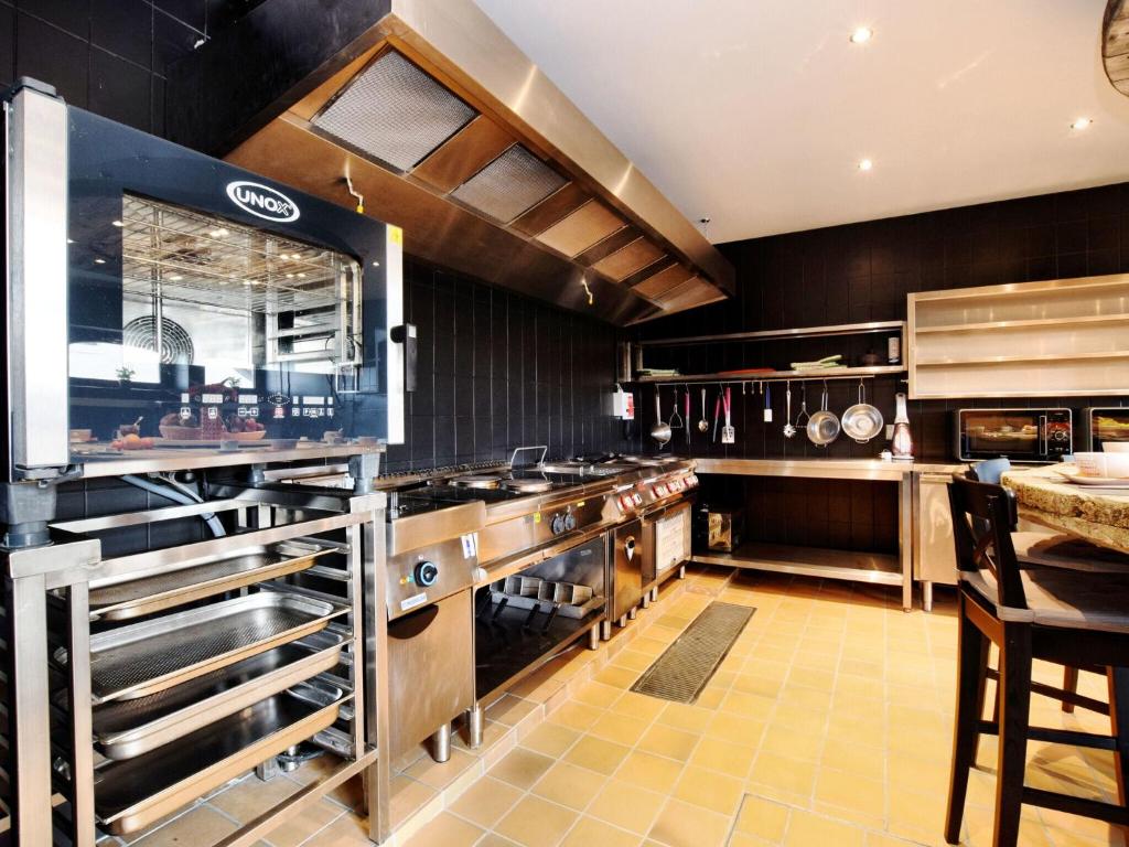 a large kitchen with wooden counters and stainless steel appliances at Fancy Holiday Home in Sainte C cile with Pool House Indoor Pool in Sainte-Cécile