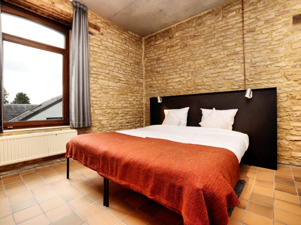 a bedroom with a bed and a brick wall at Fancy Holiday Home in Sainte C cile with Pool House Indoor Pool in Sainte-Cécile