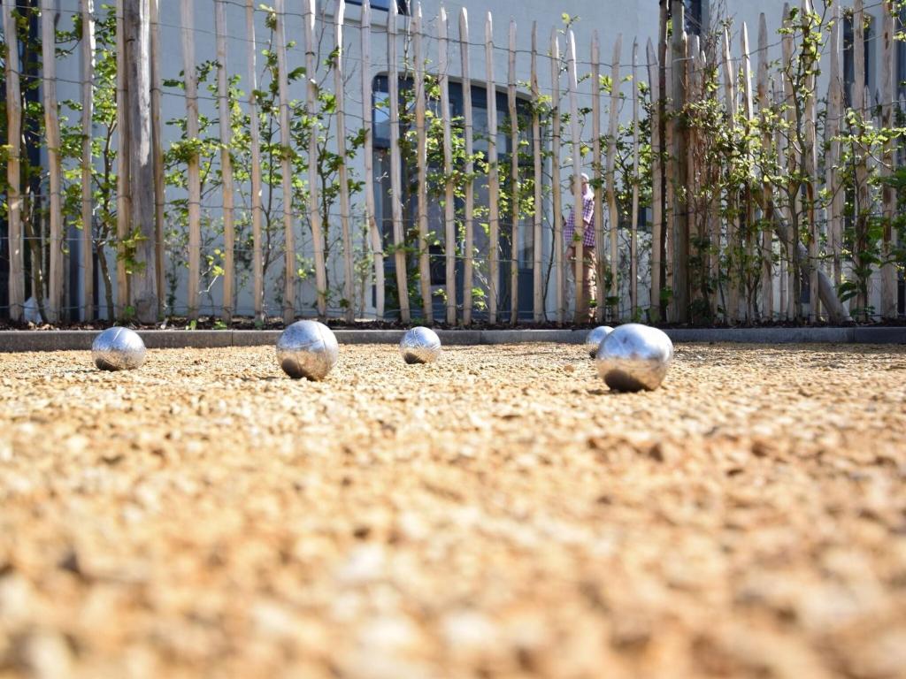 four balls on the ground in front of a fence at Fancy Holiday Home in Sainte C cile with Pool House Indoor Pool in Sainte-Cécile