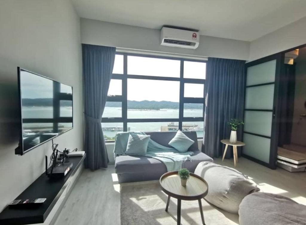 a bedroom with a bed and a large window at Loveable Home JESSELTON QUAY NEAR SURIA SABAH 亞庇晴文旅 in Kota Kinabalu