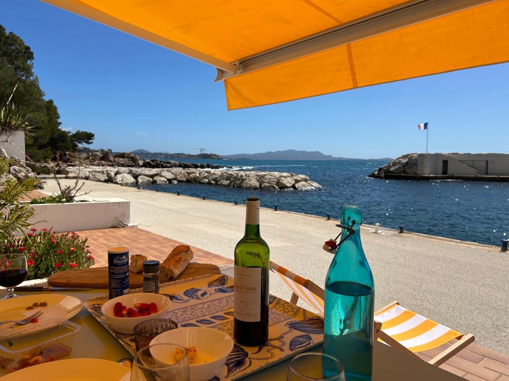 - une table avec 2 bouteilles de vin dans l'établissement Horizon Bleu Bandol : appartement pieds dans l’eau, à Bandol