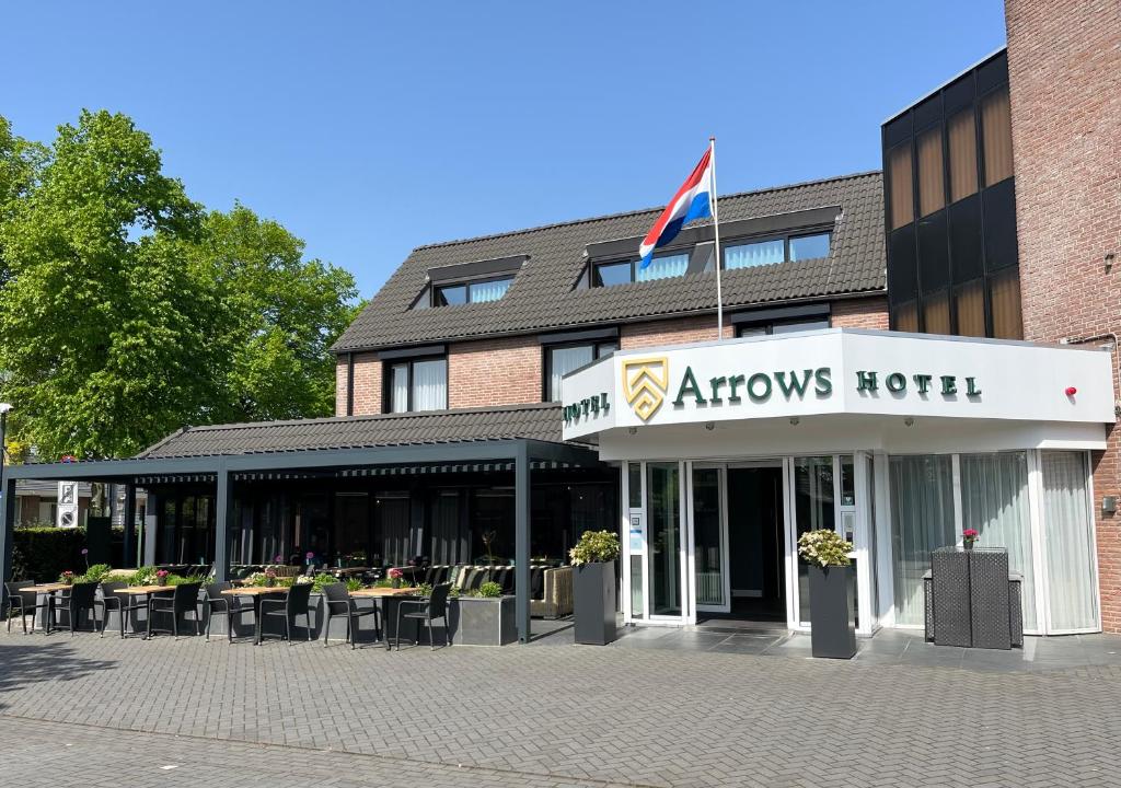 a view of an arrows hotel with tables and chairs at Hotel Arrows in Uden