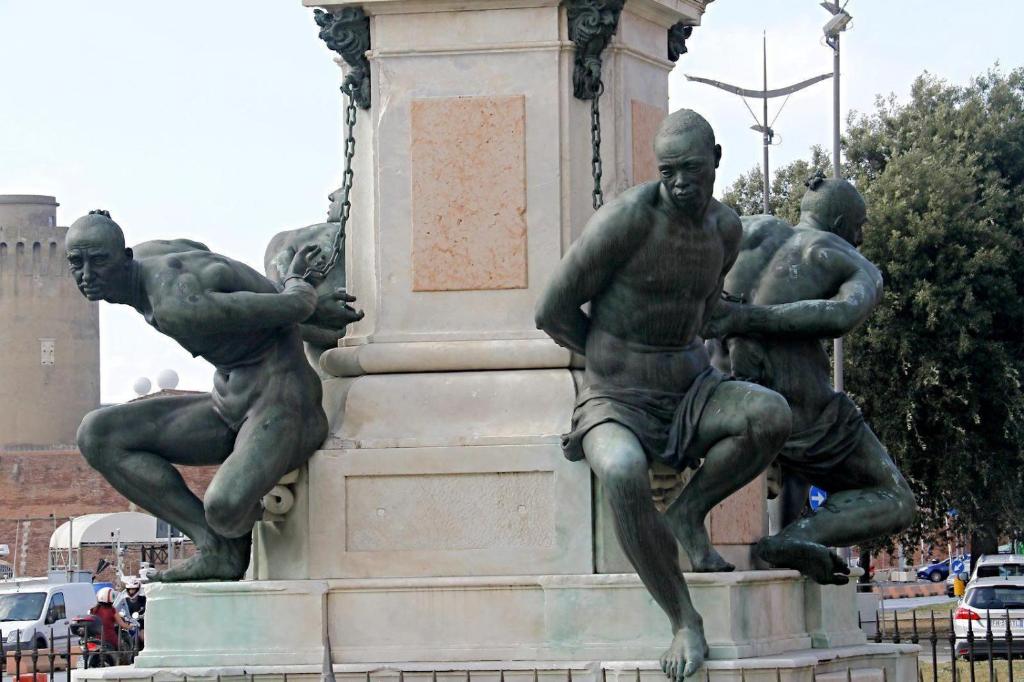 a statue of three men sitting on top of a monument at The Port Residence in Livorno