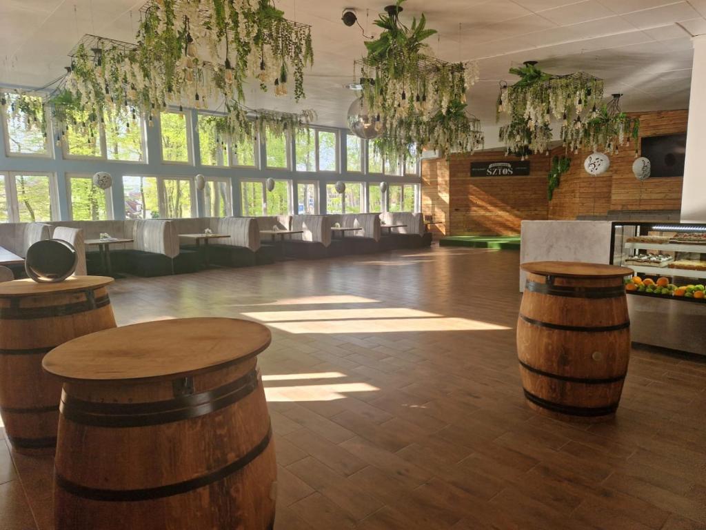 a large room with wooden stools in a room with windows at OW Gromada Pod Bukami in Międzyzdroje