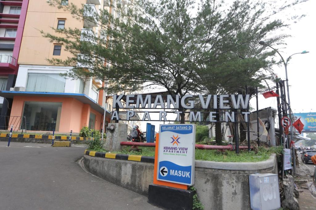 una señal frente a un edificio con un árbol en OYO 93952 Dms Property, en Bekasi