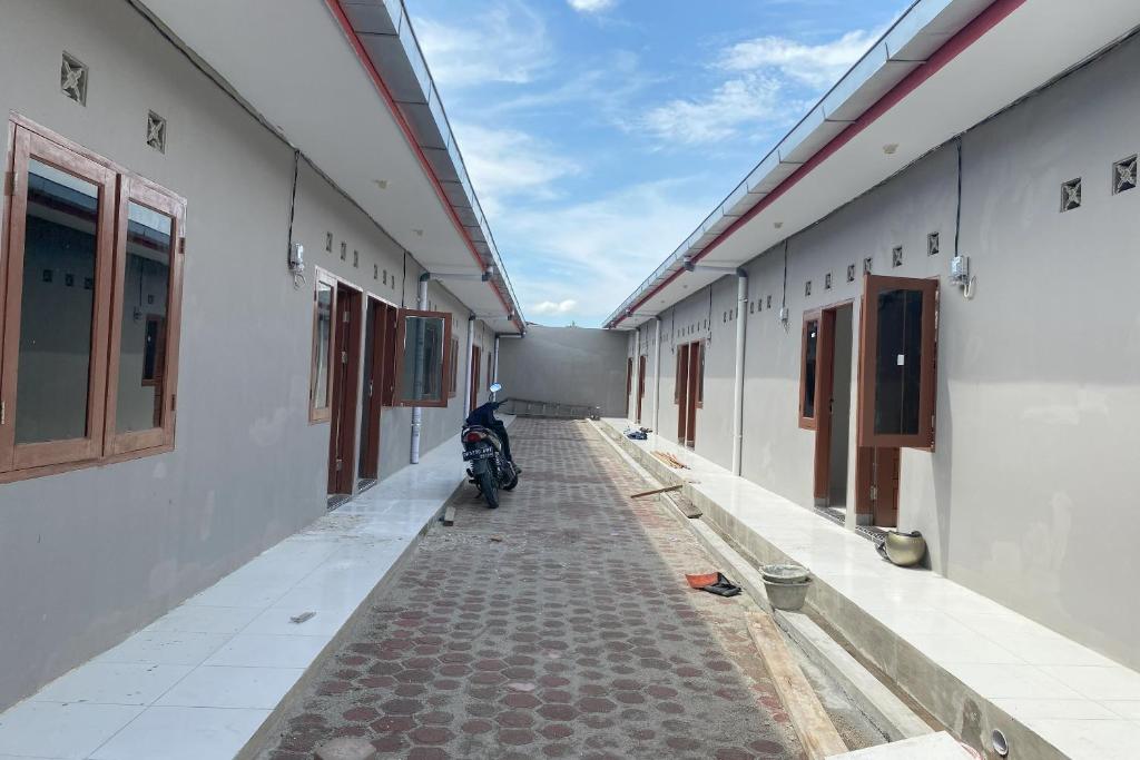 棉蘭的住宿－OYO 93951 Family Guesthouse，停在建筑物中间的摩托车