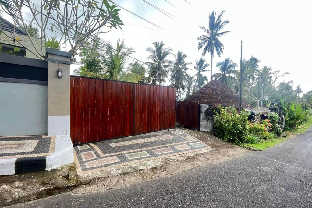 una puerta roja al lado de una calle en Capital O 93954 Meta Pandawa Bali Mounth Villa en Jembrana