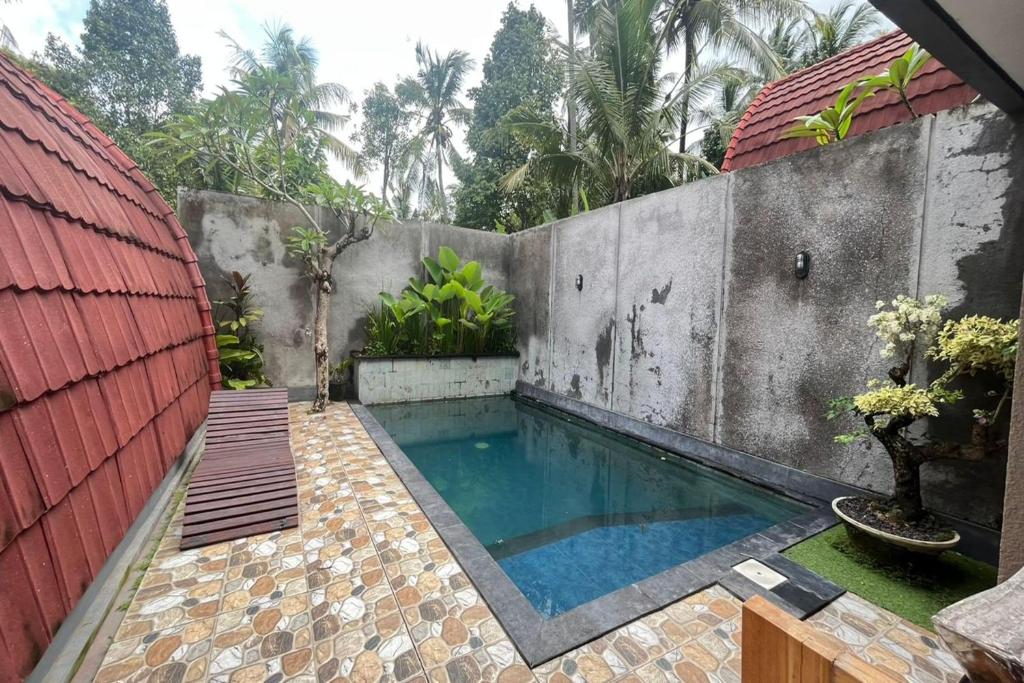 a swimming pool in a backyard with a fence at Belvilla 93954 Meta Pandawa Bali Mounth Villa in Jembrana