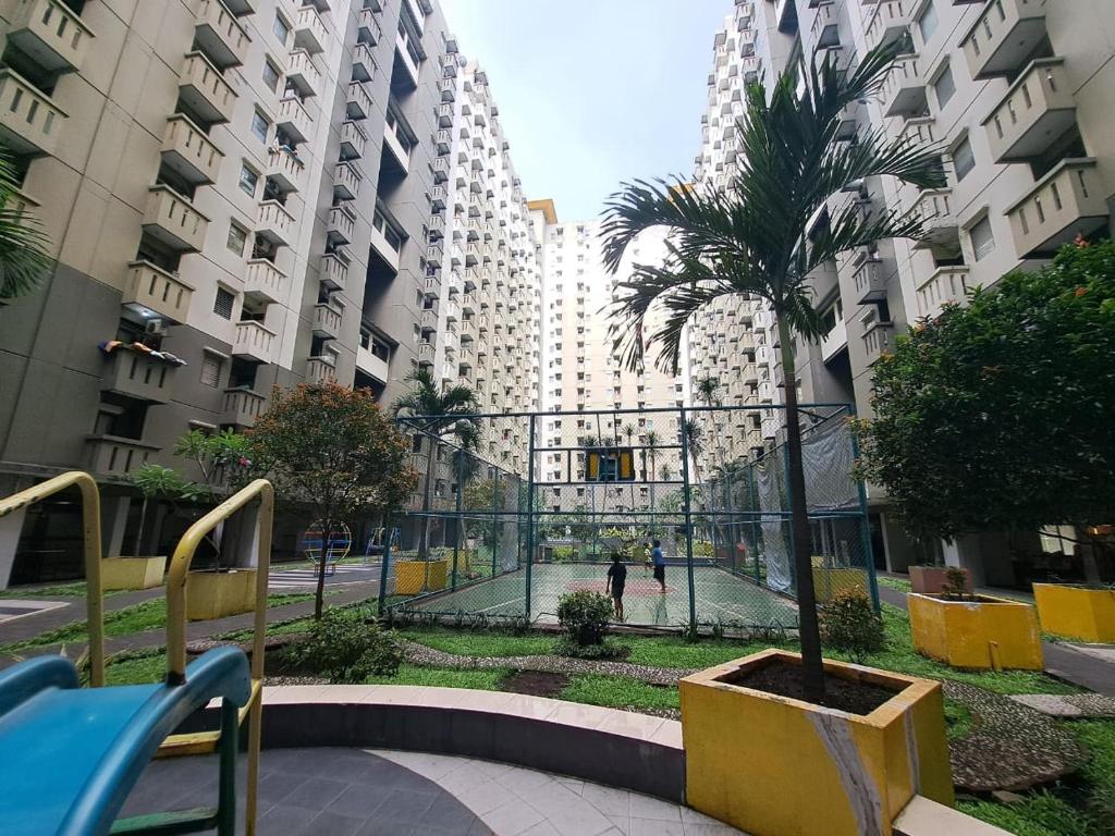una palmera en un patio de una ciudad en Capital O 93959 Apartement Gateway Cicadas By Mg Property en Bandung