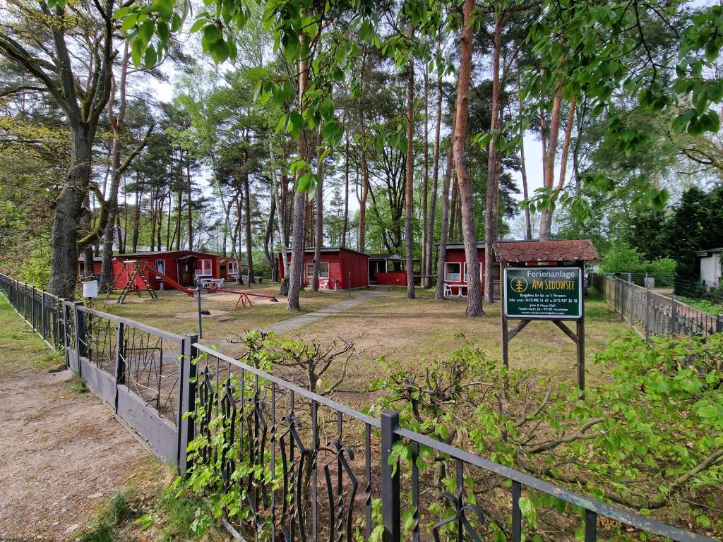 un panneau devant un parc avec un bâtiment dans l'établissement Ferienanlage "Am Sidowsee", à Himmelpfort