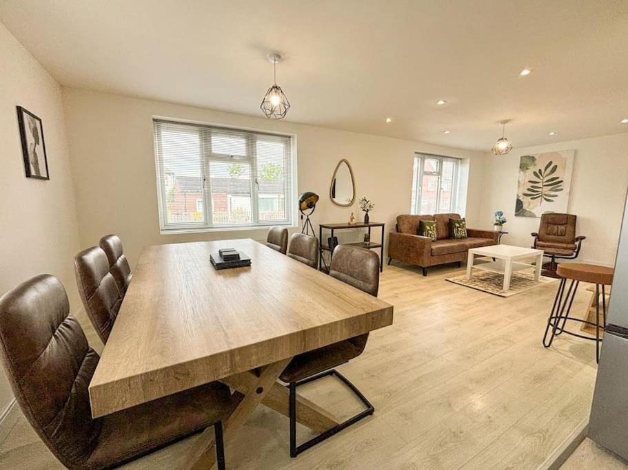 a living room with a wooden table and leather chairs at Shrewsbury Townhouse in Harlescott
