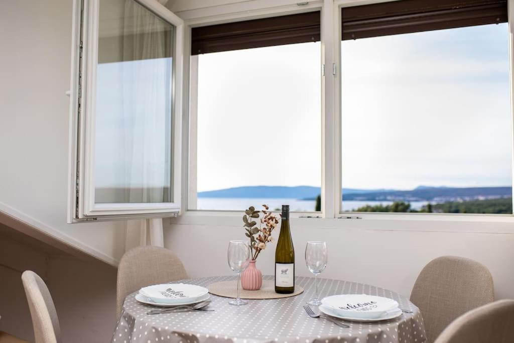 a table with a white table cloth and a bottle of wine at Apartment Olive with wonderful sea view - 500 m from beach in Punat