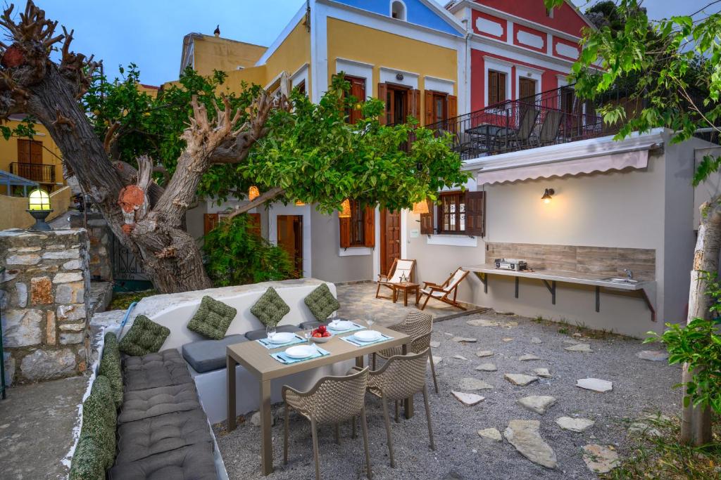 a patio with a couch and a table and chairs at Lemon Tree Symi in Symi