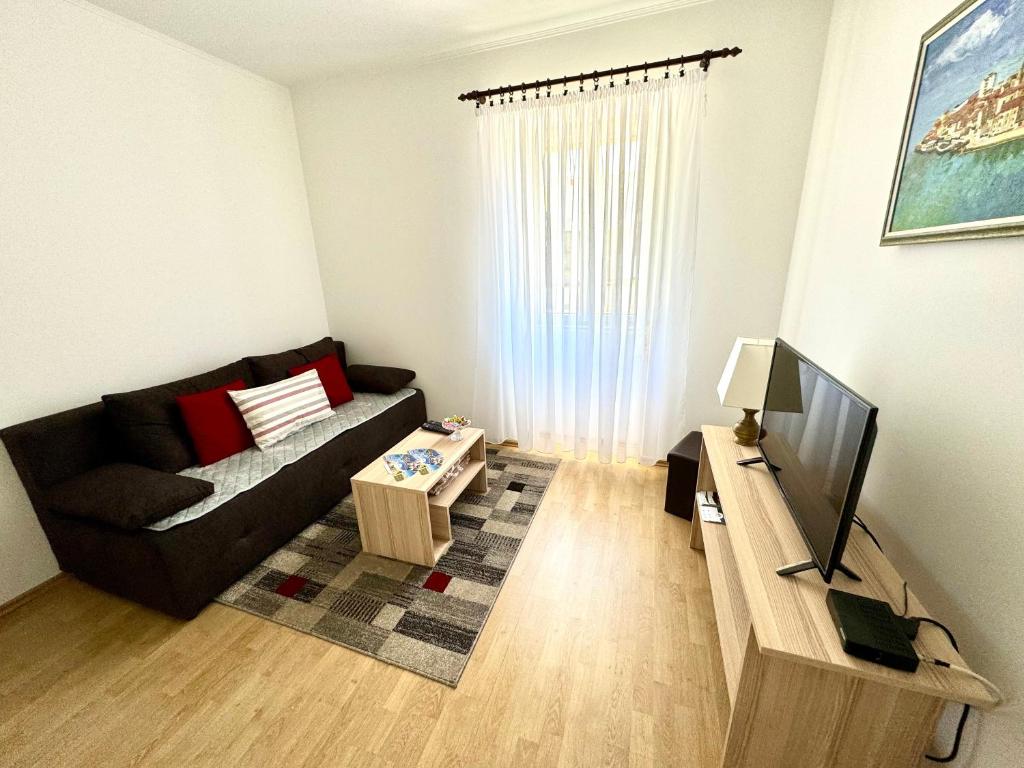 a living room with a couch and a television at Apartment Kontrada in Umag