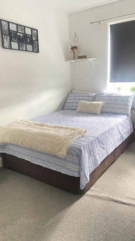 una camera da letto con un grande letto con lenzuola blu di Nice room on the friendly flat a Londra