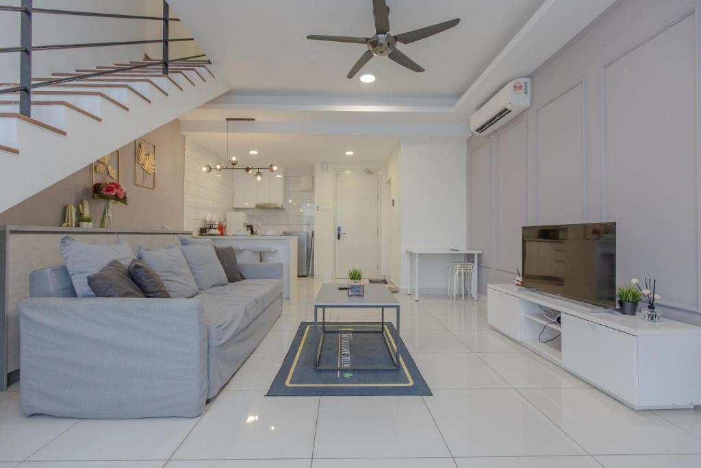een witte woonkamer met een bank en een tafel bij Duplex at Arte Mont Kiara by Bai Yi # 2501 in Kuala Lumpur